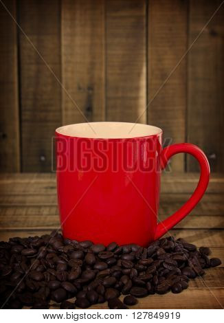 coffee beans and red cup on the wooden table Concept filter sepia
