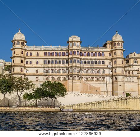 UDAIPUR INDIA - 20TH MARCH 2016: Part of the city palace in Udaipur during the day from the lake.