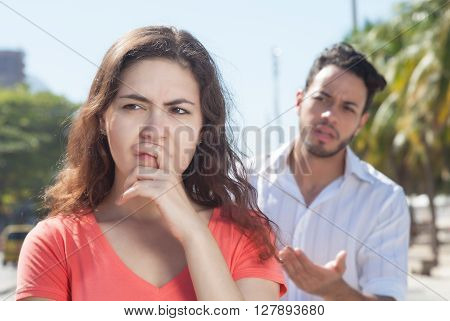 Modern couple with relationship problems in the city with modern buildings in the background