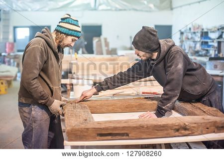 Carpenter work on wood plank in workshop