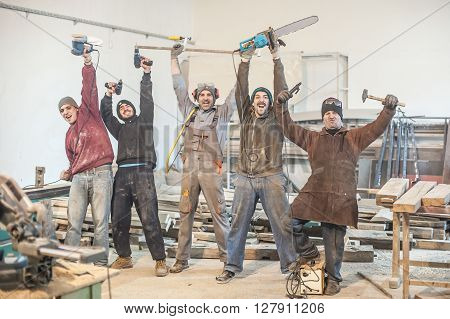 Funny Workers. Workers posing with their tools in the workshop
