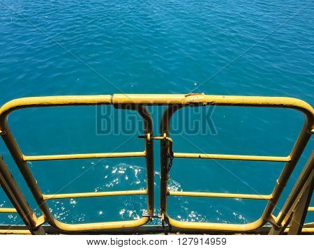 Out to blue sea, yellow gate in ferry, emergency exit to the blue sea