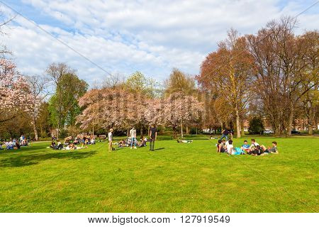 Maastricht Netherlands - April 11 2016: unidentified people lying in a park in Maastricht in spring. Maastricht is a university city and the capital of the Dutch province Limburg