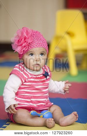 Baby girl dressed in pink with a rumba shaker
