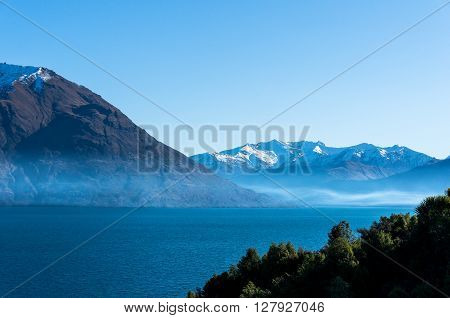 Lake Wanaka landscape with snow covered mountains. Winter mountain landscape with blue Wanaka lake. South Island, New Zealand