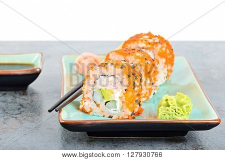 California maki sushi with masago on the plate. Roll made of crab meat, avocado, cucumber and masago.