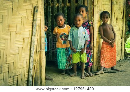 Will-will Papua New Guinea - July 2015: Small children in colourful clothes stand in house and look curiously to photocamera in Will-will Nuku Papua New Guinea. Documentary editorial.