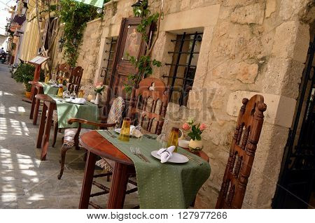 Bring down outside in front of a Greek restaurant with a magnificent facade in stones