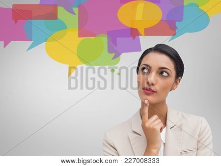 Digital composite image of businesswoman looking at speech bubble icons