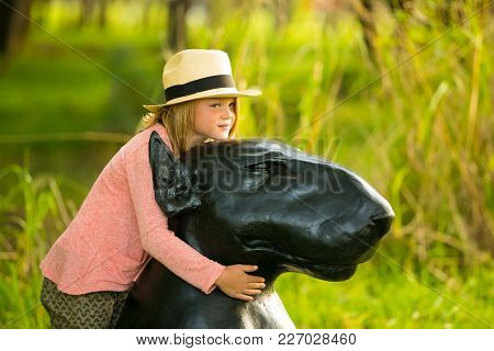 Johannesburg, South Africa, 05/10/2014, Young Girl Hugging A Dog Sculpture At The Winter Sculpture F