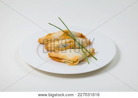 Samosa On A White Plate On A White Background Isolated