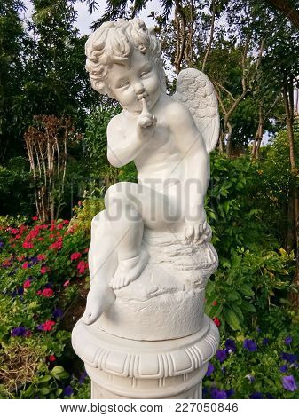 A Cute Little Cupid Statue In The Park