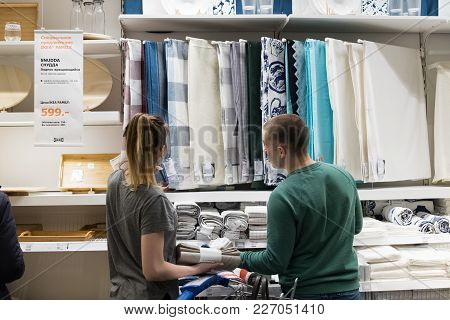 Moscow, Russia - February 10, 2018: Woman And Man Choose Liked Tablecloth For Dining Table In Ikea C