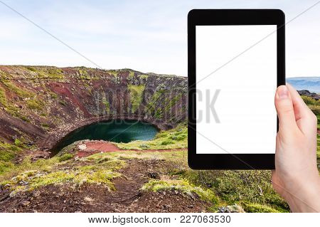 Travel Concept - Tourist Photographs Volcanic Crater With Kerid Lake In Iceland In Autumn On Tablet 