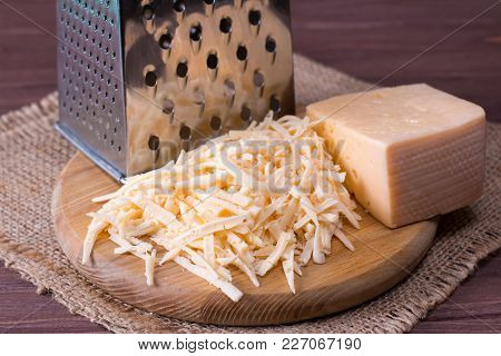 Grated Cheese On A Wooden Cutting Board Closeup