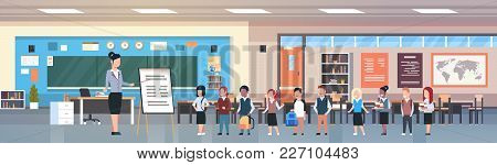 School Lesson Female Teacher With Pupils Standing In Front Of Board In Classroom Horizontal Banner F
