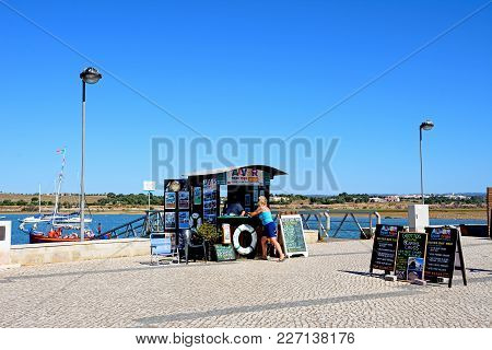 Alvor, Portugal - June 7, 2017 - Boat Trips Booking Office Along The Waterfront With Views Across Th
