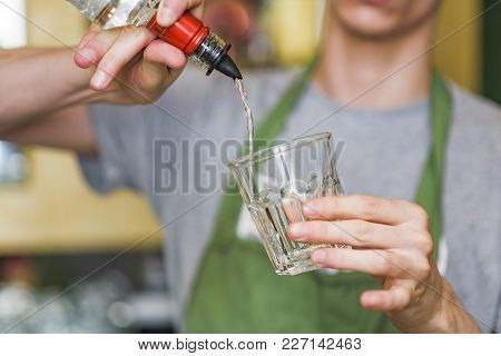 Young Bartender Making A Cocktail, Pouring Alcohol In A Cocktail Glass