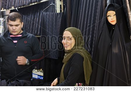 Tehran, Iran - April 29, 2017: A Smiling Muslim Girl Trades In A Black Cloth For A Religious Veil In