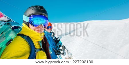 Panoramic photo of cheerful couple with snowboard on background of snowy hills