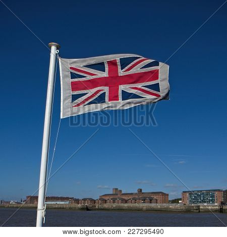 British Flag Waving On The Wind. Clear Blue Sky In The Background.