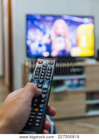 Man Holding A Remote Control While Watching The Tv