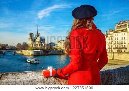 Seen From Behind Woman In Paris With Christmas Present Box