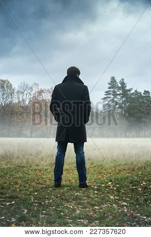 A Man In A Black Coat In Foggy Weather