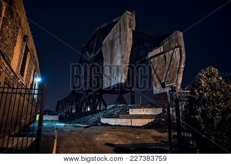 Massive industrial Chicago Bascule railroad train bridge at night.