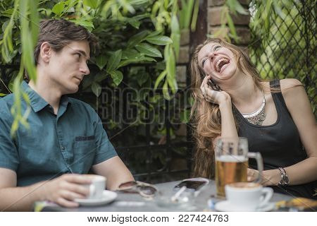 Young Men Is Bored And Stressed With His Companion Having Too Much Fun On The Phone, Ignoring Him Co