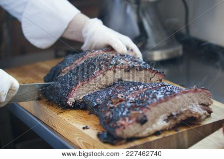 Large Piece Of Smoked Brisket Meat On A Wooden Board, Concept Of Cooking And Haute Cuisine