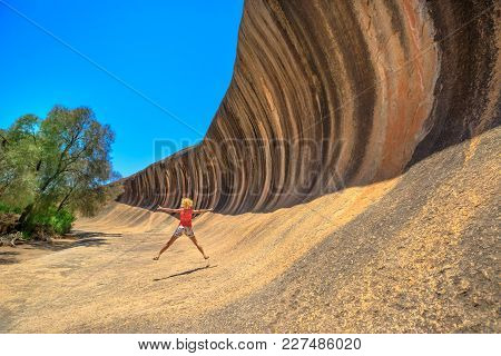 Australian Outback Freedom Concept. Happy Caucasian Woman Jumping At Wave Rock In Hyden, Western Aus