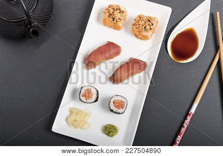 In The Image We See A Mix Of Sushi With Wasabi Sauce, On The Upper Right We See A White Porcelain Sp