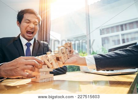 An Asian Businessman Arraging The Small Wooden Blocks On His Working Desk By Close-up, Business Cons