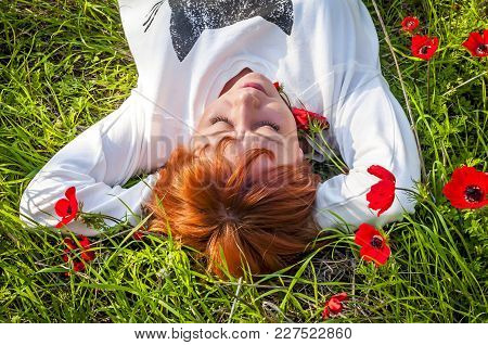 Pretty Girl With A Red Flower Behind Her Ear At The Anemone Flowering Field. Flowering Negev Desert 