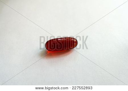 Closeup Of One Red Softgel Capsule Of Krill Oil