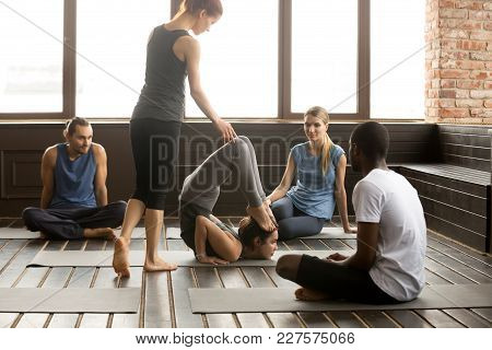 Female Instructor Helping Young Sporty Woman With Ganda Bherundasana Pose, Assisting Student With Fo