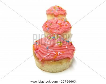 Rosa cupcakes med strössel isolerad på en vit bakgrund