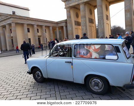 Berlin, Germany - December 3, 2017: The Retro Cat Trabant And The Brandenburg Gate
