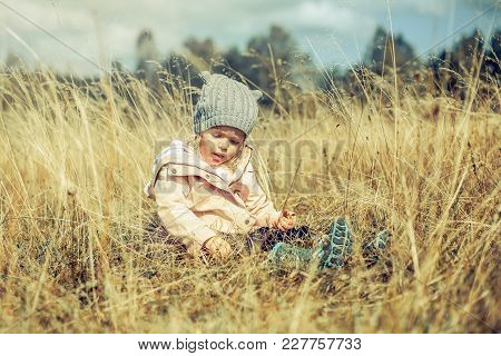 Little Beautiful Blonde Girl Looking Odonata Bug Flying Over Grass Field On A Sunny Summer Day.