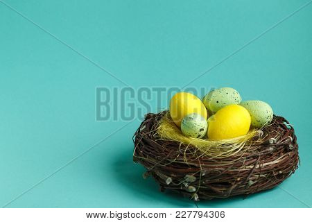 Colorful Easter Eggs In A Nest On Turquoise Background