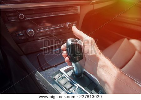 Man's Hand On An Automatic Gearbox. Automatic Shift Transmission. Sunlight.