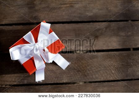A Box With A Gift On A Wooden Background. Gift. Holidays. Valentine's Day. International Women's Day