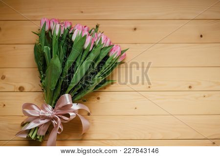 Bouquet Of Pink Tulips And Perfume With A Beautiful Bow On A Wooden Background.
