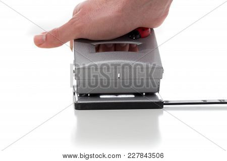 Puncher Used By A Hand Against A White Background
