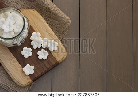 Overhead, Top-down Shot Of Some White Coconut Tapioca Cookies Spread On A Wooden Block And In A Glas