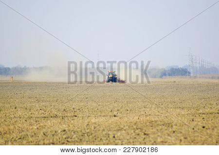 Russia, Temryuk - 19 July 2015: Tractor Rides On The Field And Makes The Fertilizer Into The Soil. C