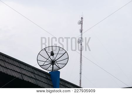 Sattlelite And Tv Antenna And Cellular Communication Antenna On The Roof With Cloud Sky.