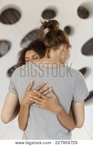 Young Mixed-race Couple In Love Hug Each Other Indoors. Shot Of A Passionate Young People In Love Ov