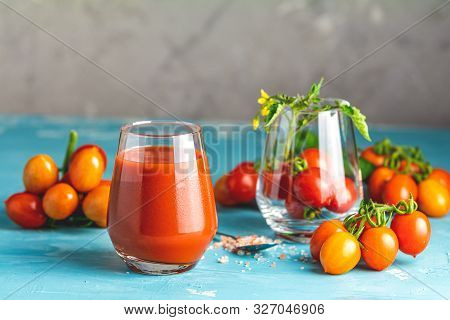 Glasses Of Fresh Delicious Jummy Red Tomato Juice And Fresh Raw Tomatoes With Pink Salt In Spoon On
